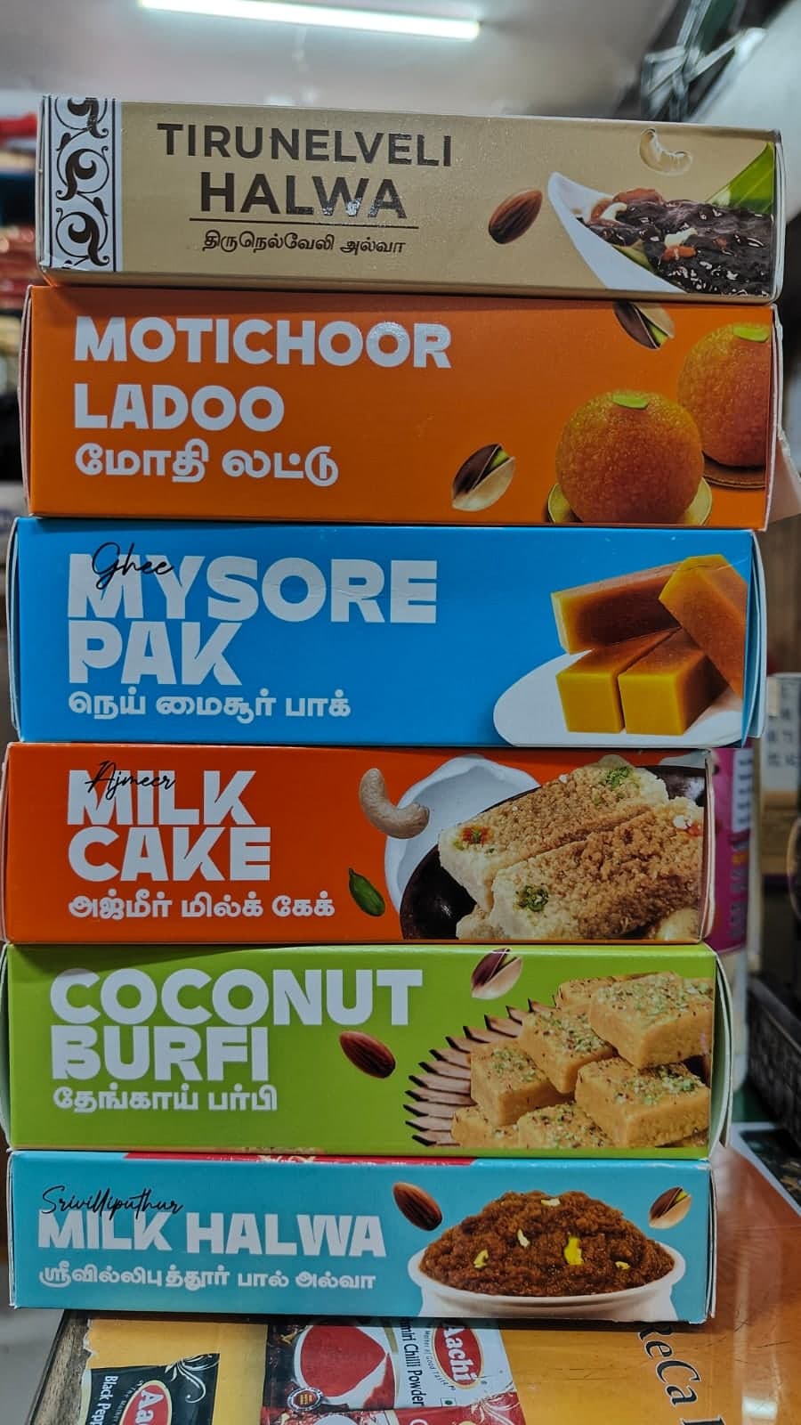 Boxes of packaged sweets stacked on a shop shelf